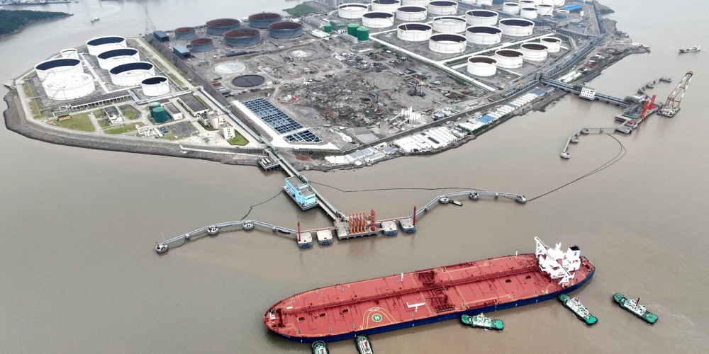 Velkoņi palīdz jēlnaftas tankkuģim piestāt naftas terminālī pie Vaidiao salas Džoušanā, Džedzjanas provincē, Ķīnā.