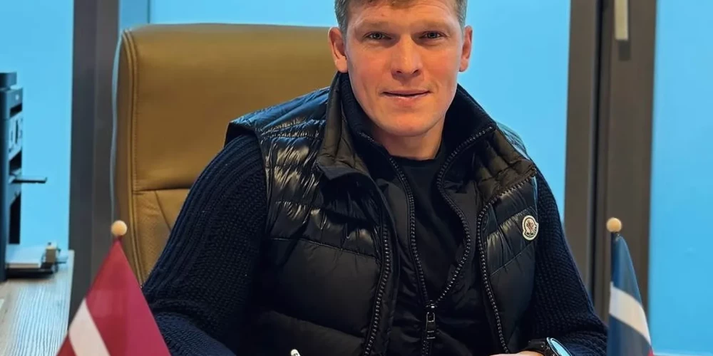 Artjoms Rudņevs liek savu parakstu uz darba līguma.