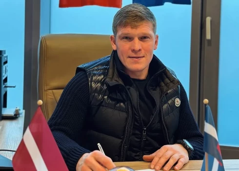 Artjoms Rudņevs liek savu parakstu uz darba līguma.