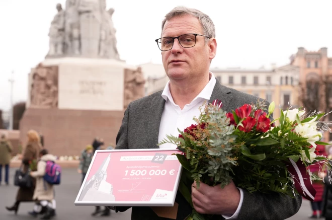 Мэр Виестурс Клейнбергс получает сертификат на страховку Памятника Свободы.