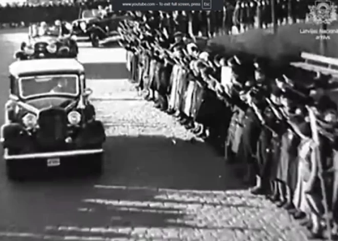 1935. gada 18. novembrī tūkstošiem latviešu Valsts prezidenta un valdības vadītāja kortežu uz Brīvības pieminekļa atklāšanu sveicina ar izstieptu labo roku.