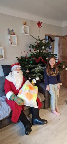 Vectēvs, pārģērbies par Ziemassvētku vecīti, iepriecina mazmeitu Elizabeti.