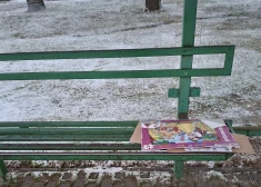 Pasažieri pieturā piesalst pie metāla soliņa, gaidot autobusu Vangažos