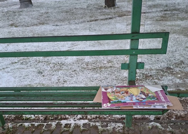 Pasažieri pieturā piesalst pie metāla soliņa, gaidot autobusu Vangažos