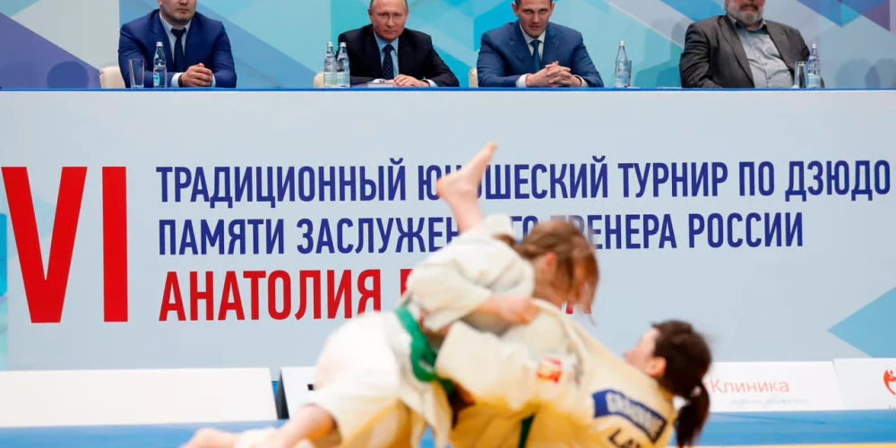 Vladimirs Putins (fonā pa vidu) noraugās Krievijā notiekošās džudo sacensības.