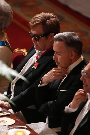 Eltons Džons ar partneri Deividu Fērnišu valsts banketā Vindzoras pilī, kas tika rīkots par godu Francijas prezidenta vizītei šā gada 8. jūlijā.