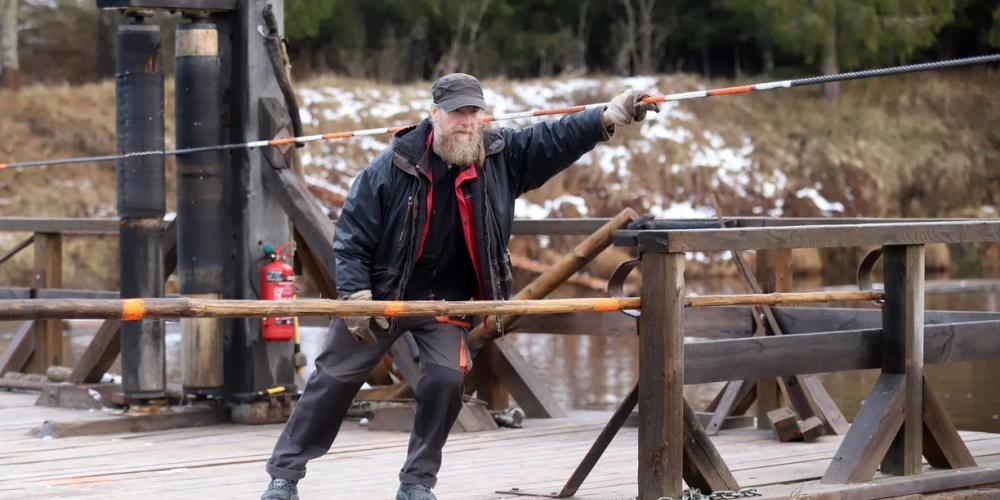 Dienā, kad ierodamies uz pārceltuvi, mums pretī dodas Kārlis Logins – vīrs ar garu bārdu, kura āriene momentā liek atcerēties to, cik bieži senākās reliģijās un literāros darbos īpatnēja un svarīga loma ir pārcēlājam.
