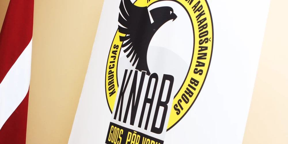 Korupcijas novēršanas un apkarošanas biroja logotips un Latvijas valsts karogs.