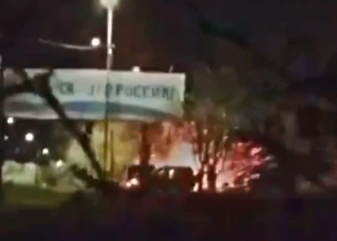 Krievijas karavīru grupa pulcējās zem propagandas reklāmas stenda pie iebraukšanas okupētajā Berdjanskā.