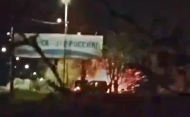 Krievijas karavīru grupa pulcējās zem propagandas reklāmas stenda pie iebraukšanas okupētajā Berdjanskā.