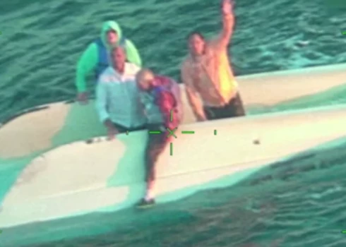 Četri vīrieši uz apgāztā katamarāna sagaida glābējus (ekrānuzņēmums no video)
