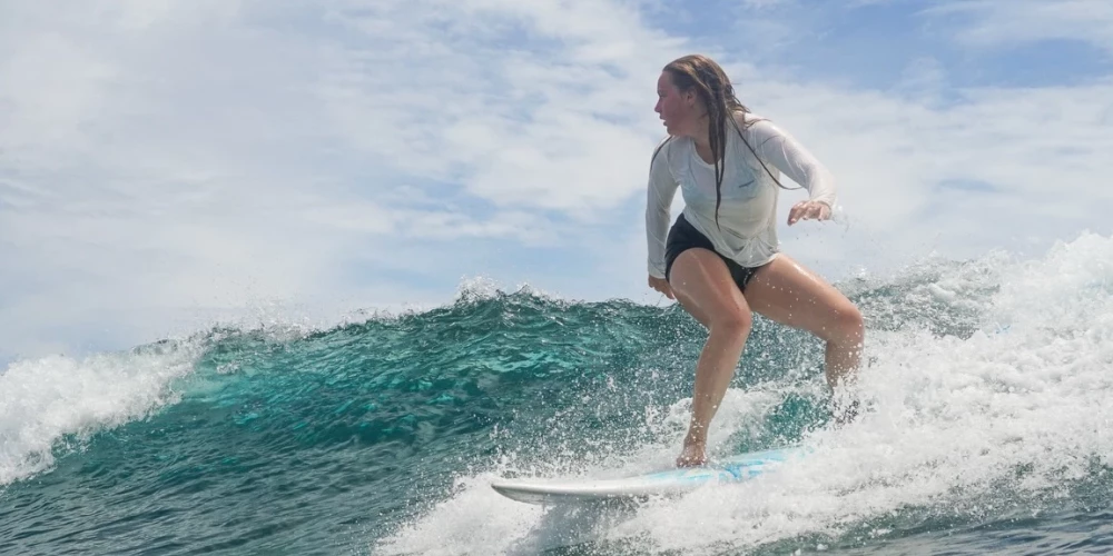 Aija, drosmīgi sērfojot viļņos.