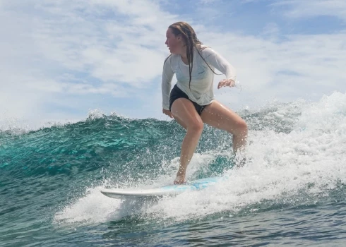 Aija, drosmīgi sērfojot viļņos.