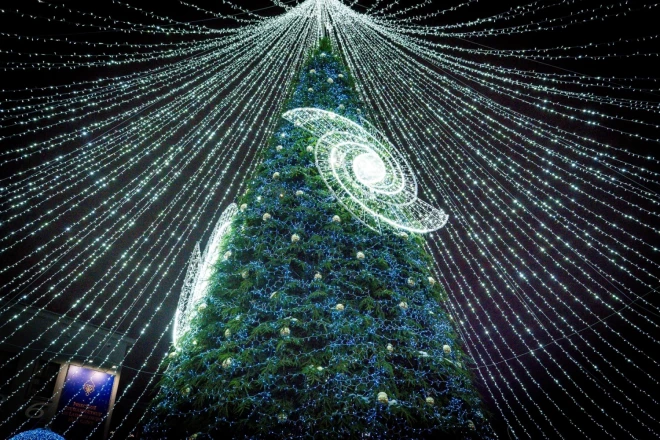 В этом году ель превратилась в символическую ось Вселенной, на ветвях которой сияют бесчисленные галактики, символизируя мечты, которые всегда достижимы.