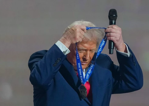 Ar miera prēmijas balvu apsēstais Tramps viņam pasniegoto medaļu kaklā uzkāra pats.