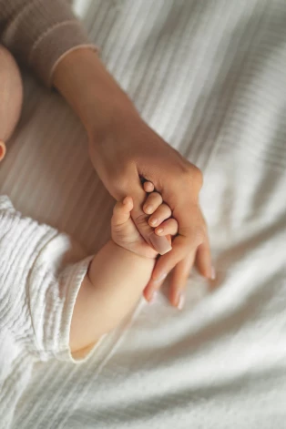 baby holding mother's finger, cute motherhood, New mom and newborn baby hands close up