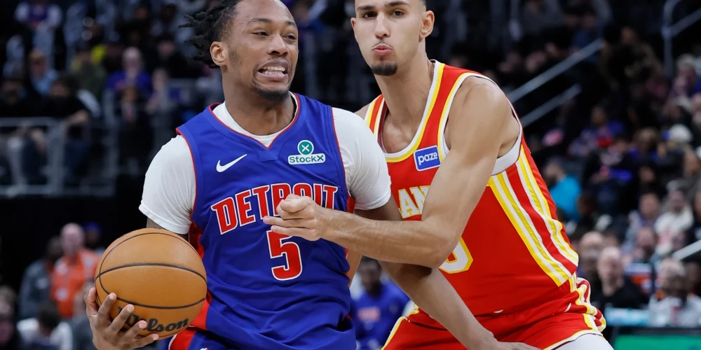 Detroit Pistons forward Ronald Holland II, left, drives to the basket against Atlanta Hawks forward Zaccharie Risacher (10) during the second half of an NBA basketball game Friday, Dec. 12, 2025, in Detroit. (AP Photo/Duane Burleson)