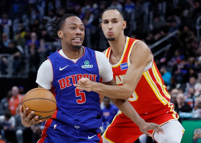 Detroit Pistons forward Ronald Holland II, left, drives to the basket against Atlanta Hawks forward Zaccharie Risacher (10) during the second half of an NBA basketball game Friday, Dec. 12, 2025, in Detroit. (AP Photo/Duane Burleson)