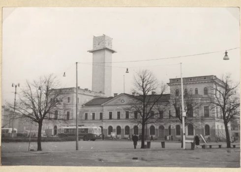 На переднем плане — исторический железнодорожный вокзал Рига (строительство началось в 1858 году; здание вокзала построено по проекту архитектора Иоганна Даниэля Фелско, в 1884–1885 годах вокзал расширили по проекту Генриха Шеля). На заднем плане видна постройка часовой башни нового здания Рижского вокзала (автор фото — Н. Судрабиньш, 1965 год).