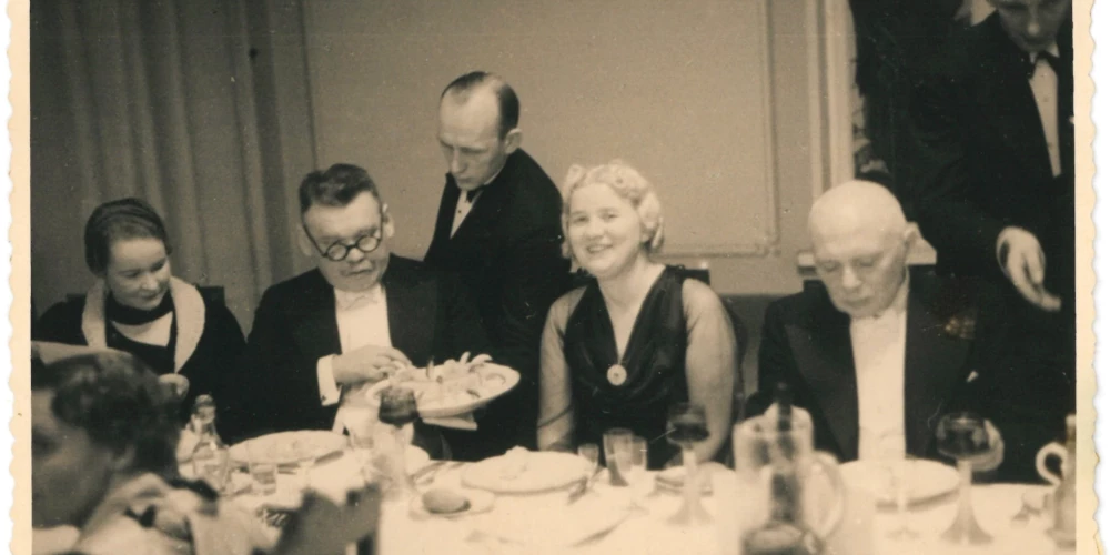 3. Latvijas ārstu un zobārstu kongresa svinīgais mielasts 1932. gadā Rīgā. Fotogrāfs nav zināms. No kreisās puses: zobārste Lūcija Sniķers, Pēteris Sniķers, Elga Raiska (dz. Žubecka), profesors Jēkabs Alksnis. Foto no pētnieka Mārtiņa Vespera arhīva.