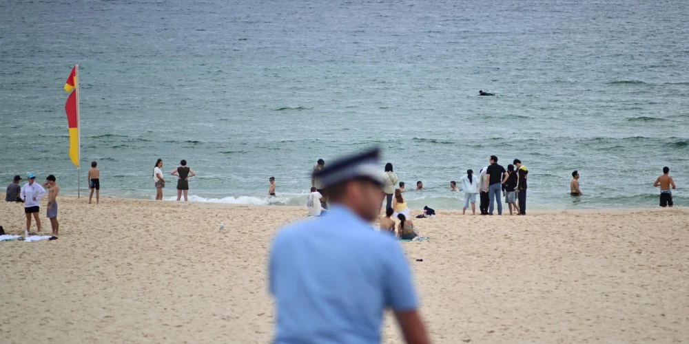 Policija vēro apkārtni Bondi pludmalē. 