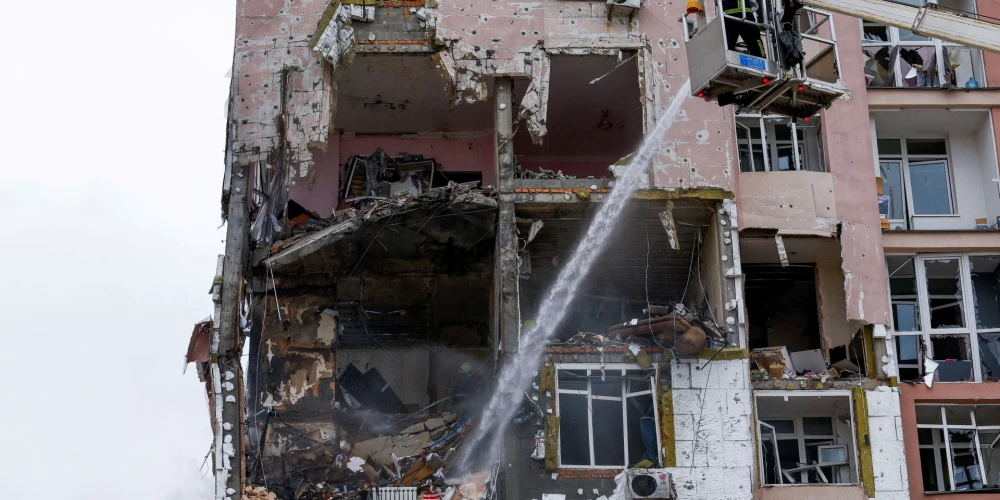 Пожарные работают на месте попадания по жилому дому, пострадавшему в результате российских ракетных и дроновых ударов по Киеву во время атаки России на Украину.