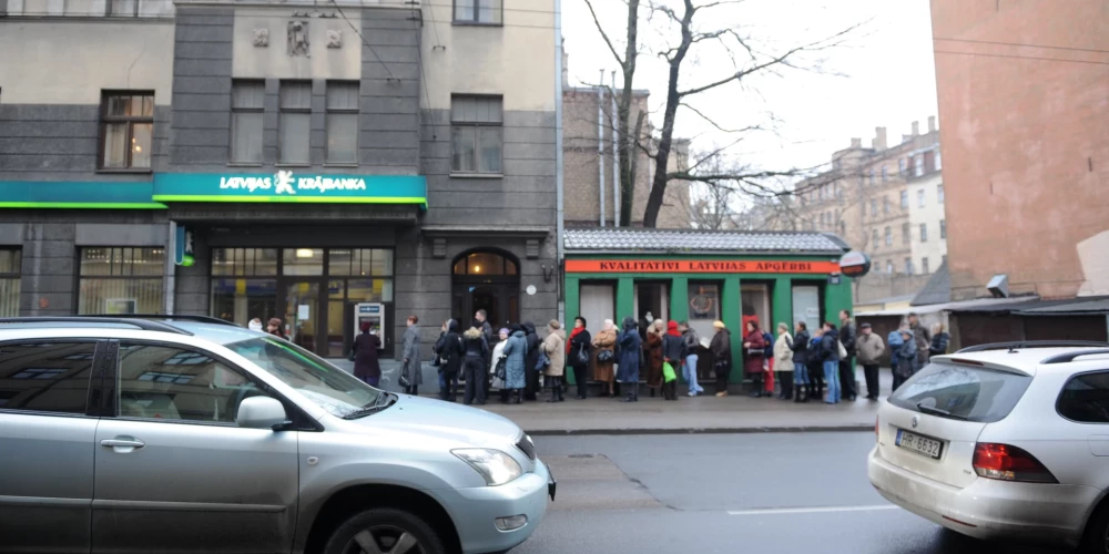 Люди стоят в очереди за своими деньгами после закрытия Latvijas Krājbanka.