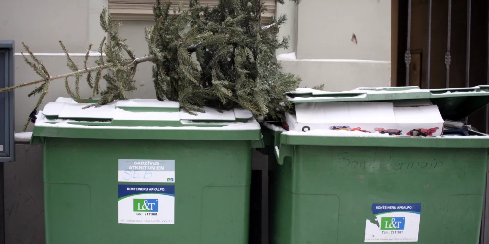 Atkritumu konteineri ar eglīti.