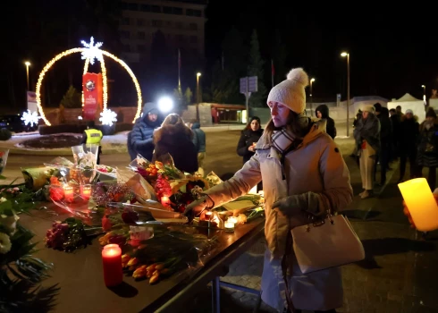 Sieviete noliek ziedus pie bāra “Le Constellation”.
