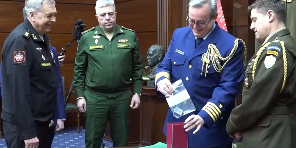 ASV vēstniecības pārstāvis nevarēja noturēties un pasmējās, kad ievietoja kontrolieri kastē.