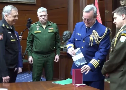 ASV vēstniecības pārstāvis nevarēja noturēties un pasmējās, kad ievietoja kontrolieri kastē.