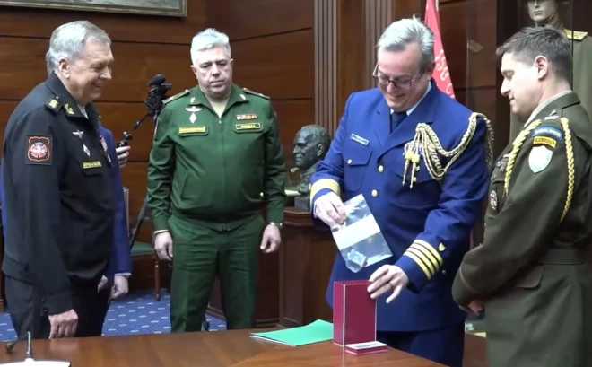 ASV vēstniecības pārstāvis nevarēja noturēties un pasmējās, kad ievietoja kontrolieri kastē.