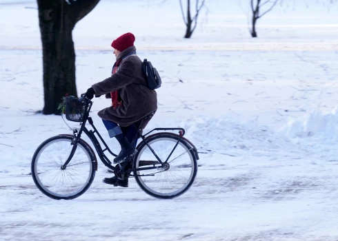 Sieviete ar velosipēdu Vērmanes dārzā.