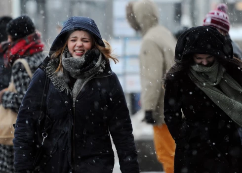 Cilvēki sniegputenī.