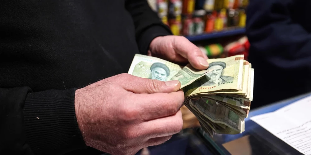 Владелец магазина пересчитывает иранские банкноты в Тегеране, Иран, 7 января 2026 года.