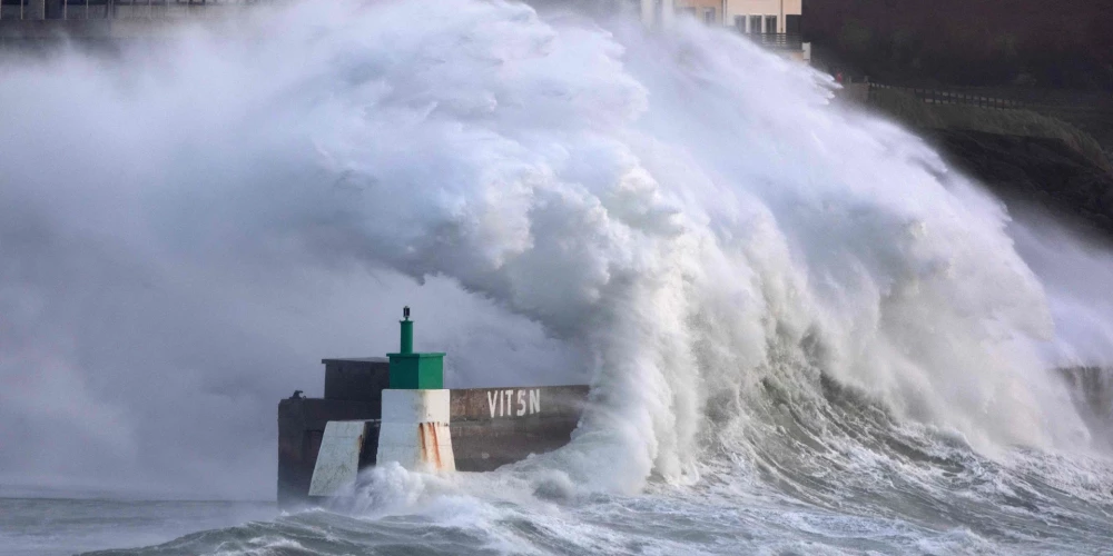 TOPSHOT - A huge wave crashes on the jetty of the harbor of Le Conquet, western France on January 8, 2026 as storm Goretti is announced to approach France's northern coasts. The northwest of France, barely recovered from a snowfall episode, is preparing on January 8, 2026 to face storm Goretti, with wind gusts that could reach 160 km/h in the Manche, a department under red alert where schools will be closed on January 9, 2026. (Photo by Fred TANNEAU / AFP)