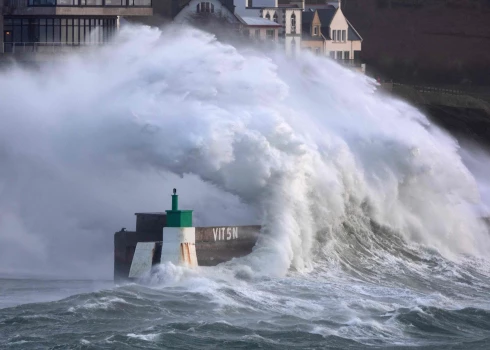 TOPSHOT - A huge wave crashes on the jetty of the harbor of Le Conquet, western France on January 8, 2026 as storm Goretti is announced to approach France's northern coasts. The northwest of France, barely recovered from a snowfall episode, is preparing on January 8, 2026 to face storm Goretti, with wind gusts that could reach 160 km/h in the Manche, a department under red alert where schools will be closed on January 9, 2026. (Photo by Fred TANNEAU / AFP)
