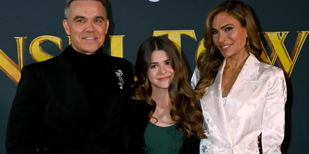 Robijs Viljamss ar sievu Aīdu Fīldu un meitu Tediju filmas “Tinsel Town” pirmizrādes vakarā 2025. gada 27. novembrī Londonā.