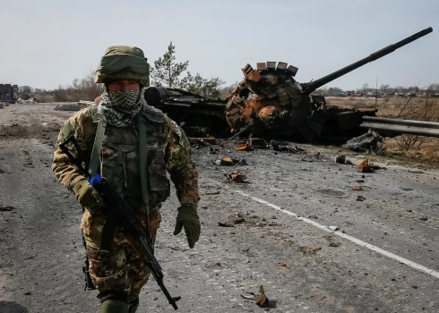Ukrainas karavīrs iet garām iznīcinātam Krievijas tankam Kijivas apgabalā. 2022. gada 28. marts.