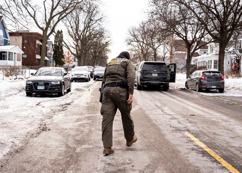 Federālais aģents klibojot atgriežas pie transportlīdzekļa pēc tam, kad paslīdēja un nokrita uz ledus patruļas laikā Mineapolisā, Minesotas štatā, 2026. gada 11. janvārī.
