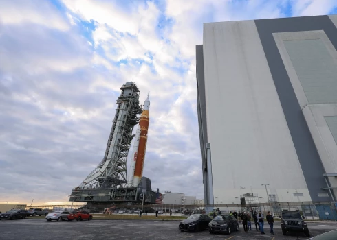 Rītausmā 98 metrus augsto raķeti no Kenedija Kosmosa centra montāžas ēkas sāka lēnām pārvietot uz starta platformu, un sešus kilometrus ceļš ilgs līdz tumsai.