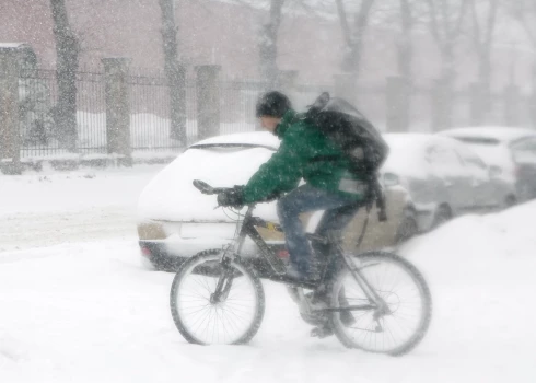 Riteņbraucējs uz ielas puteņa laikā.