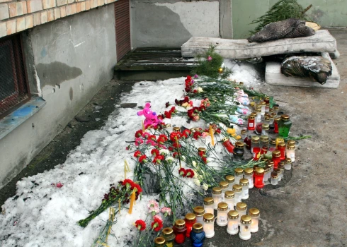 Ziedi un svecītes vietā, kur 2006. gada 6. janvāra ugunsgrēkā pa astotā stāva logu Mirdzas Ķempes ielā izlēca abi vecāki un trīs bērni