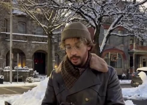 Kadrs no video - Maksims Galkins ar bārdu bauda ziemu.