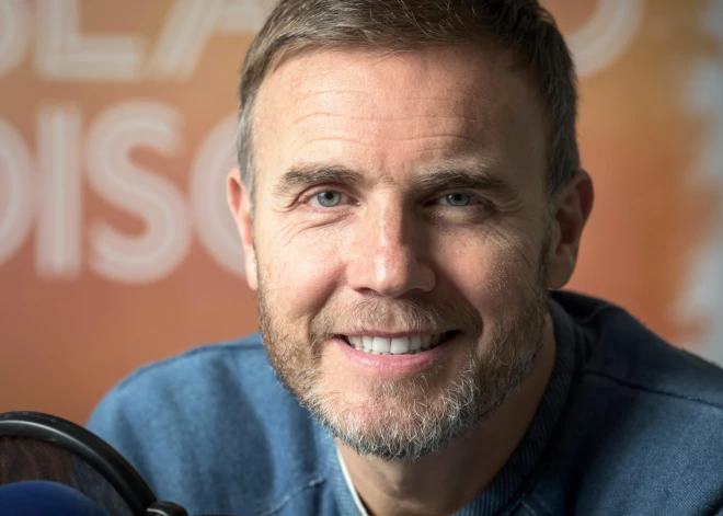"Take That" zvaigzne Garijs Bārlovs iziet no telpas, kad intervijā uzdod neērtu jautājumu par Robiju Viljamsu. Ko viņam pavaicāja?