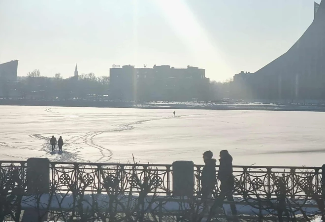 Cilvēki uz aizsalušās Daugavas.