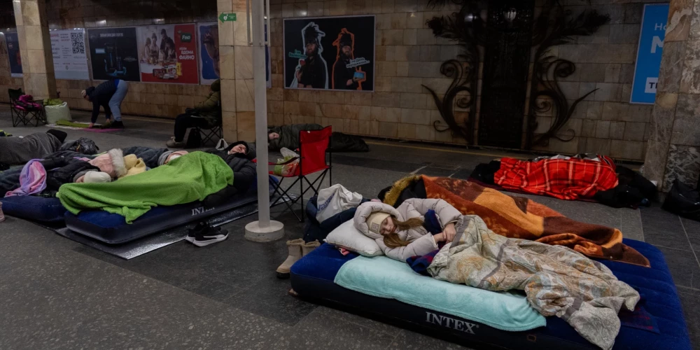 Люди укрываются на станции метро, ​​используемой в качестве бомбоубежища, во время атаки российских беспилотников в Киеве.