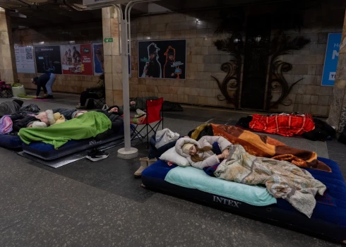 Люди укрываются на станции метро, ​​используемой в качестве бомбоубежища, во время атаки российских беспилотников в Киеве.