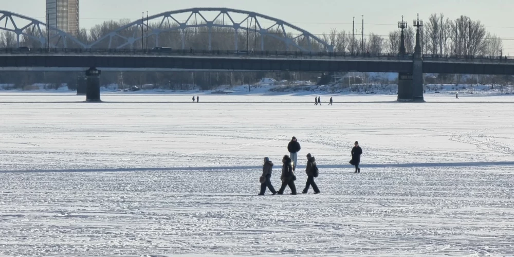 Rīdzinieki drosmīgu šķērso aizsalušo Daugavu.