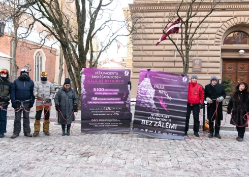 Trešdienas rītā Vecrīgā aptuveni 20 cilvēku pulcējās pie Saeimas nama, lai mudinātu politiķus atrast finansējumu onkoloģisko slimību medikamentu kompensēšanai un nenovērtēt pacientu dzīvības zemāk par valsts budžeta prioritātēm.